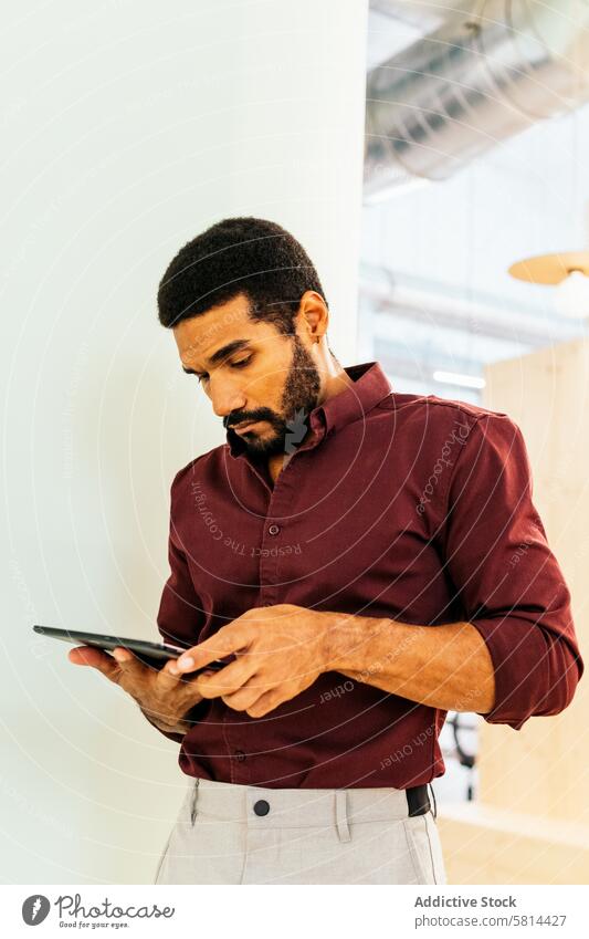 Hübscher lateinamerikanischer Mann arbeitet mit einem Tablet in einem Coworking Business Arbeit Arbeiter Lifestyle Manager Geschäftsmann Tablette professionell