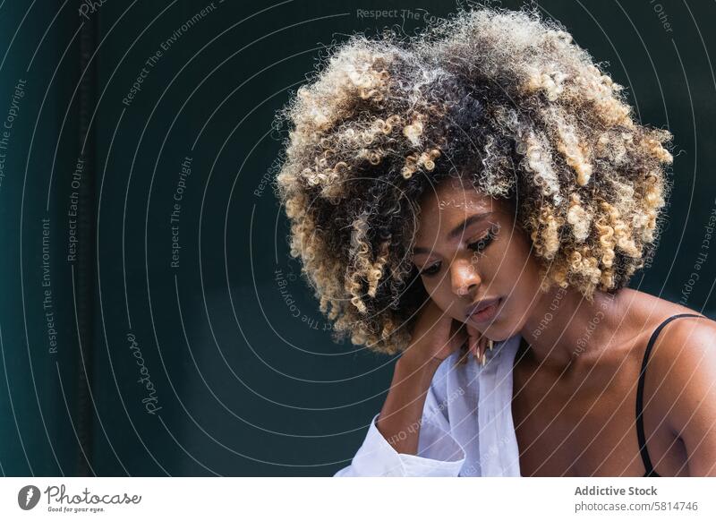 Nachdenklich stilvolle schwarze Frau steht in der Nähe von bunten Tür Stil cool tausendjährig ernst nachdenklich Treppenhaus jung Afro-Look besinnlich