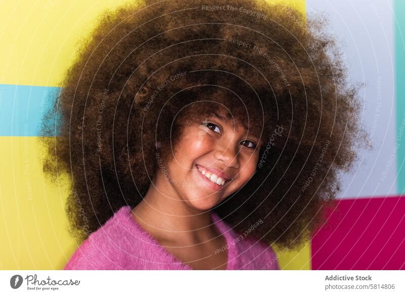 Inhalt Ethnisches Mädchen winkt mit der Hand in die Kamera Hallo Lächeln heiter Teenager Afro-Look Frisur ethnisch schwarz Afroamerikaner froh krause Haare Hi