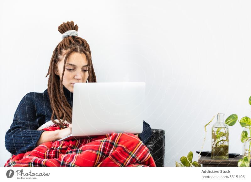 Frau mit Dreadlocks bei der Arbeit mit einem Laptop zu Hause heimwärts Computer Sofa Sitzen Raum Internet Technik & Technologie Menschen Lifestyle jung Mädchen