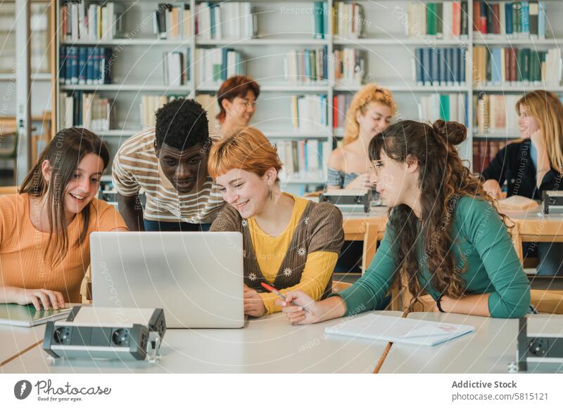 Verschiedene Studenten diskutieren Daten auf einem Laptop Schüler Projekt analysieren Bibliothek Zusammensein Lächeln Bildung lernen Teenager Jugendlicher jung