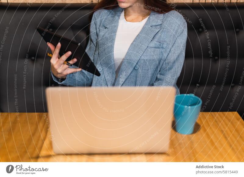 Anonyme Geschäftsfrau benutzt Tablet im Restaurant Tablette benutzend Daten freiberuflich abgelegen Projekt Tisch Frau jung Laptop Touchscreen Unternehmer
