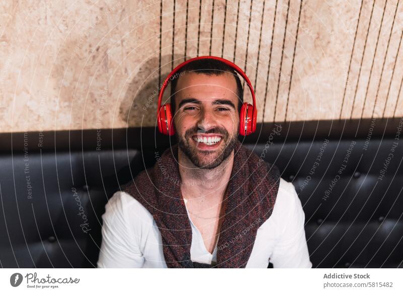 Glücklicher Mann beim Musikhören Lächeln zuhören meloman Hobby Kopfhörer Drahtlos männlich Erwachsener genießen heiter unterhalten froh Inhalt Gesang Klang
