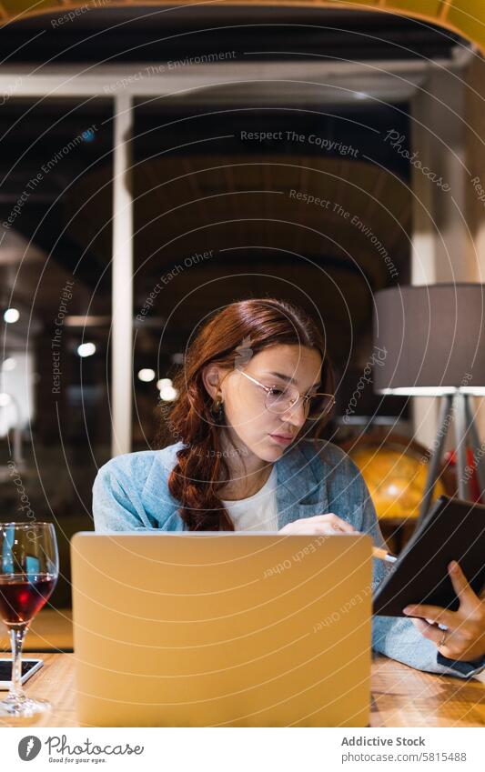 Junge Geschäftsfrau benutzt Tablet im Restaurant Tablette benutzend Daten freiberuflich abgelegen ernst Projekt Tisch Frau jung Rotwein Laptop Touchscreen