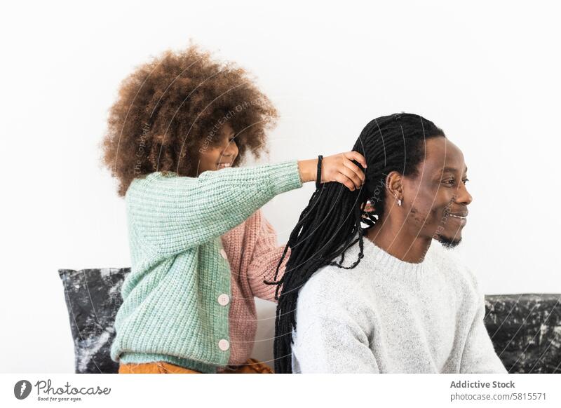 Erstauntes Mädchen macht Frisur auf Dreadlocks von Vater Tochter erstaunt Schock Spaß Spiel aufgeregt spielen Freude genießen Mann Papa Vaterschaft lustig wow