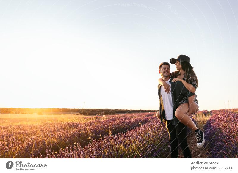 Hübsches junges Paar in einem Blumenfeld Lavendel Sonnenuntergang Liebe Frau Sommer purpur Feld Glück Zusammensein schön Natur Mann romantisch Partnerschaft