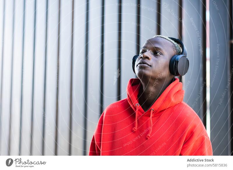 Inhalt schwarzer junger Mann, der mit Kopfhörern Musik hört zuhören genießen meloman trendy Glück sich[Akk] entspannen Gesang männlich Afroamerikaner ethnisch