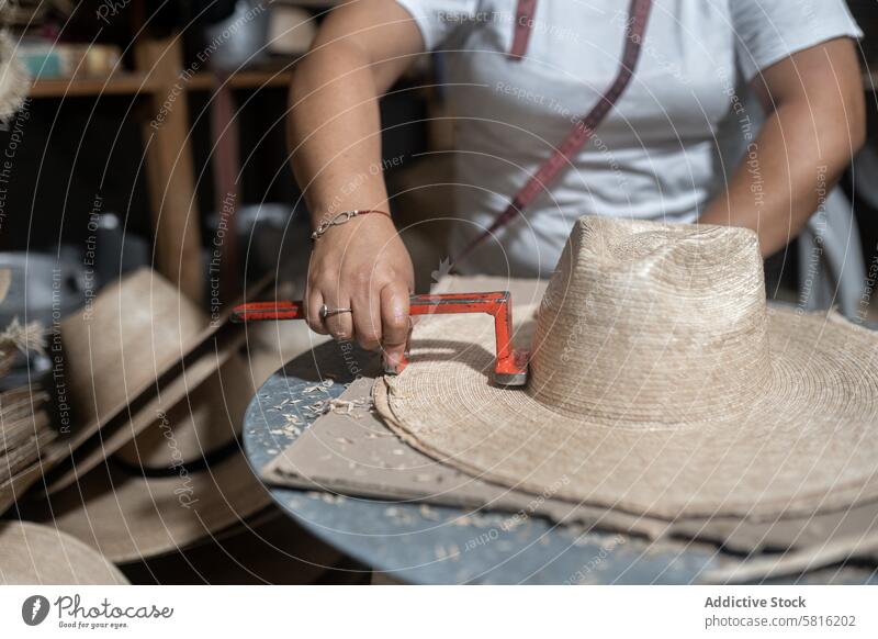 Schneiden der Krempe eines traditionellen Naturfaserhutes Messung randvoll Hut Palme Maßband Frau Erwachsener hispanisch Basteln Hutmacherei Schneider Werkstatt