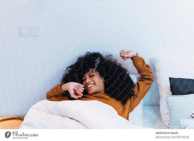 Lächelnde schwarze Frau, die im Bett aufwacht aufwachen Morgen Dehnung Wochenende zu Hause sich[Akk] entspannen ruhen Afroamerikaner Augen geschlossen
