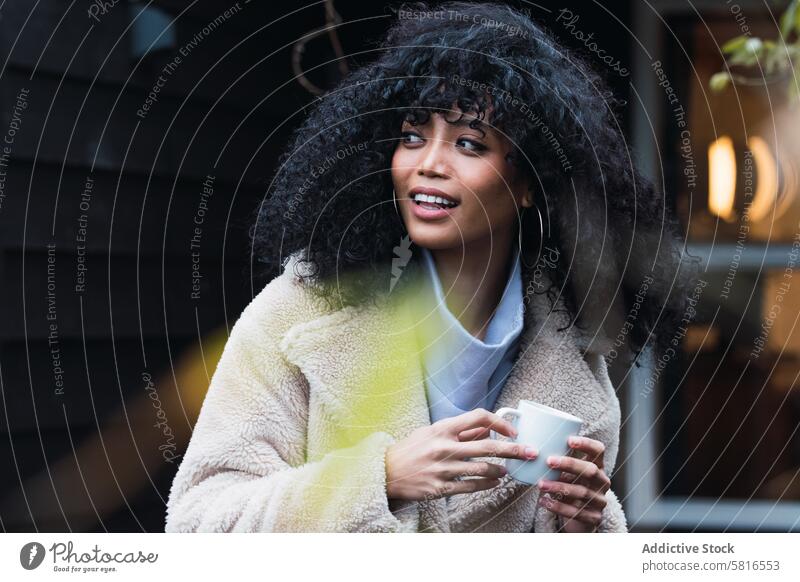 Lächelnde schwarze Frau mit einer Tasse Kaffee trinken sich[Akk] entspannen ruhen Haus heimwärts Kälte Kaffeepause warm afroamerikanische Frau Becher