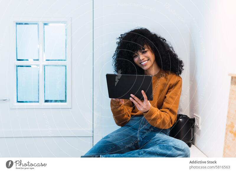 Schwarze Frau mit Tablette auf dem Tresen benutzend Küche online Kälte zu Hause Freizeit sich[Akk] entspannen Internet Porträt schwarz Afroamerikaner Browsen