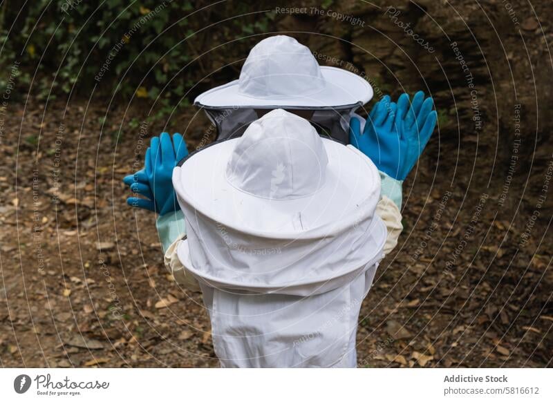 Gesichtslose Gruppe von Kindern in Schutzkleidung in einem Bienenstock Tracht behüten Zusammensein Garten Landschaft Sicherheit Handschuh Gummi Bienenkorb Wiese