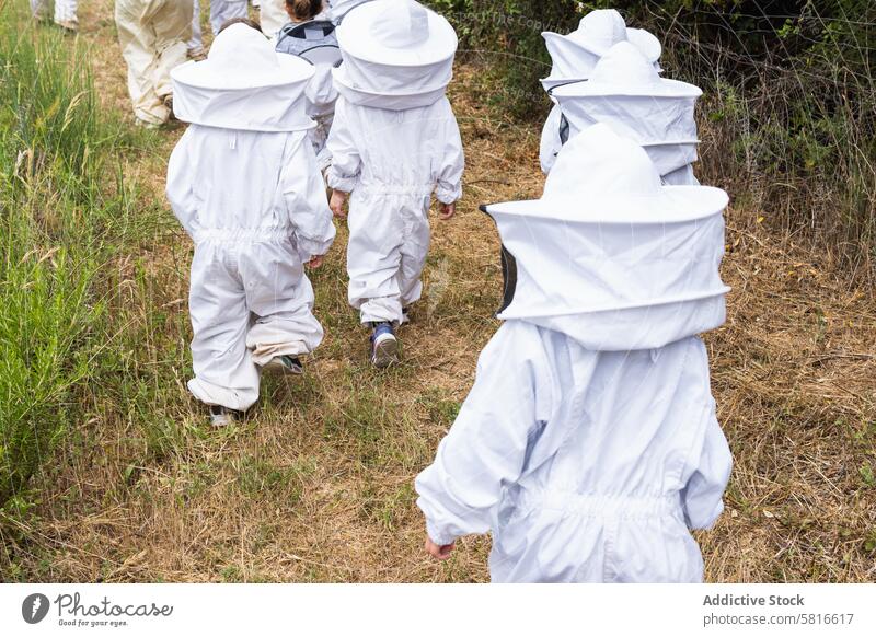 Gesellschaft von Kindern in Schutzanzügen im Bienenstock Bienenkorb Imker Tracht behüten Zusammensein Unternehmen Garten Sicherheit Landschaft Handschuh Gummi