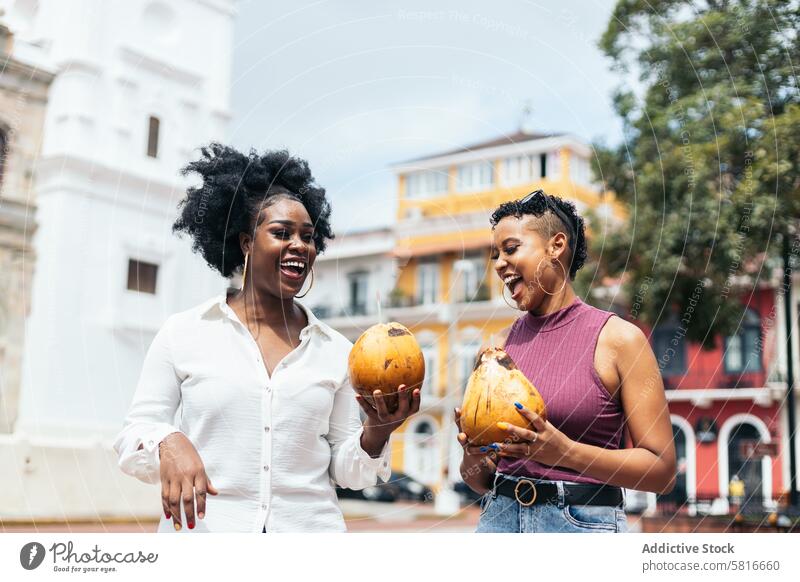 Lateinamerikanische Frauen, die sich in der Stadt amüsieren und Kokosnüsse trinken Glück jung Sommer im Freien Menschen Freizeit Lifestyle freudig Freude