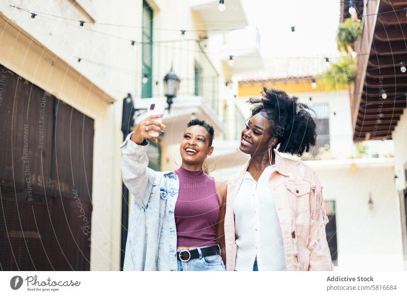 Glückliche Frauen machen Selfies mit Smartphone beim Spaziergang in der Stadt jung Sommer Telefon im Freien Menschen Spaß Freizeit Lächeln Lifestyle Foto