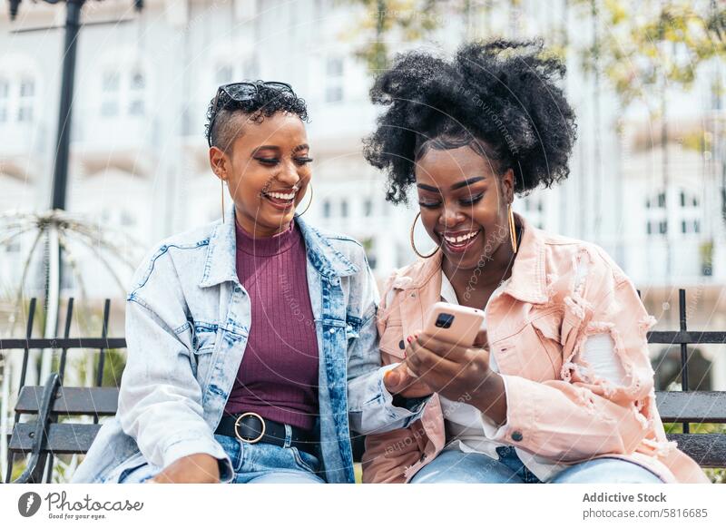 Schwarze Frauen Freunde mit Smartphone haben Spaß in der Stadt Glück jung Sommer im Freien Menschen Freizeit Lifestyle Foto freudig Freude Blick Frühling Genuss