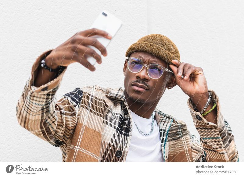Stilvoller schwarzer Mann macht Selfie Straße urban Smartphone lässig Stirnrunzeln Großstadt modern männlich ethnisch Afroamerikaner cool Outfit Lifestyle
