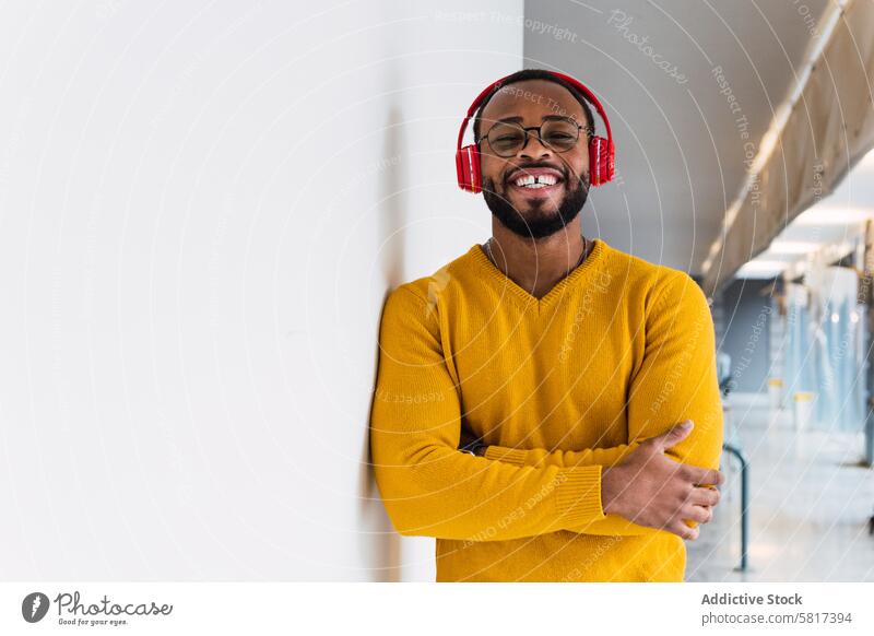 Schwarzer Mann, der mit Kopfhörern Musik hört Lächeln benutzend zuhören sich[Akk] entspannen ruhen Kälte Gesang Freude meloman männlich Glück schwarz froh
