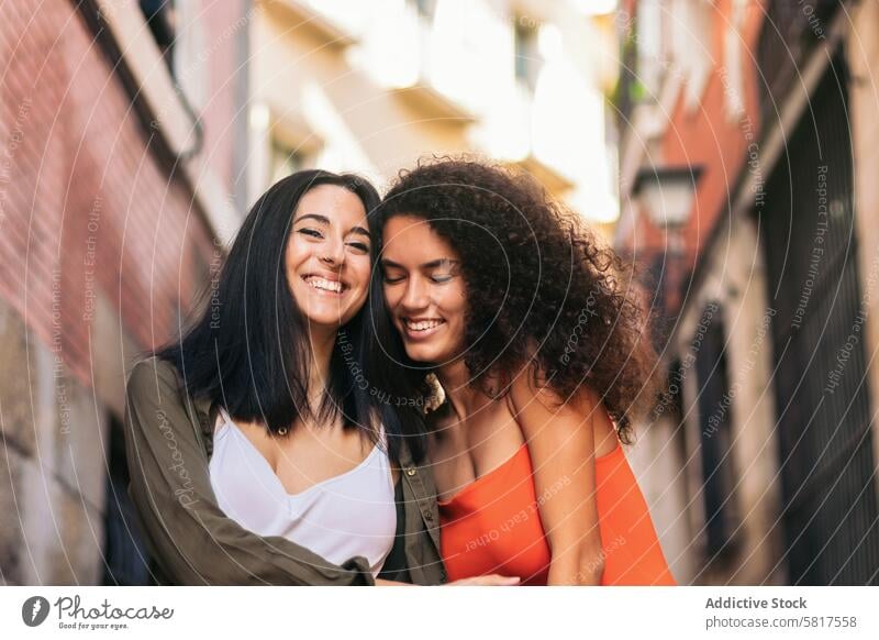 zwei junge Frauen gehen lächelnd die Treppe hinunter, halten ihre Hände und umarmen sich Glück Straße schön Menschen Mädchen Lächeln Kaukasier Lifestyle