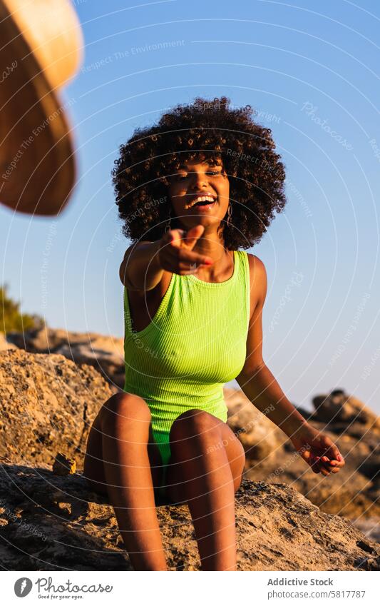 Ethnische Frau, die ihren Hut in die Kamera wirft werfen Strohhut Strand Sommer Urlaub Spaß haben heiter Badeanzug ethnisch schwarz Afroamerikaner
