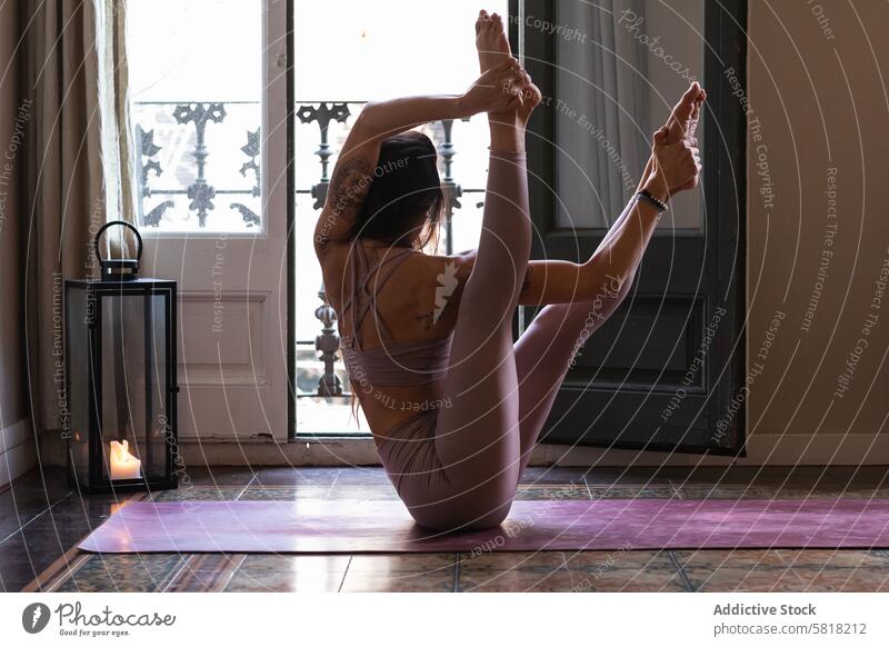 Unerkennbare Frau in Bootspose zu Hause Yoga Dehnung beweglich Wohlbefinden Energie Vitalität Gleichgewicht angehobene Beine heimwärts Talent Boot-Pose üben