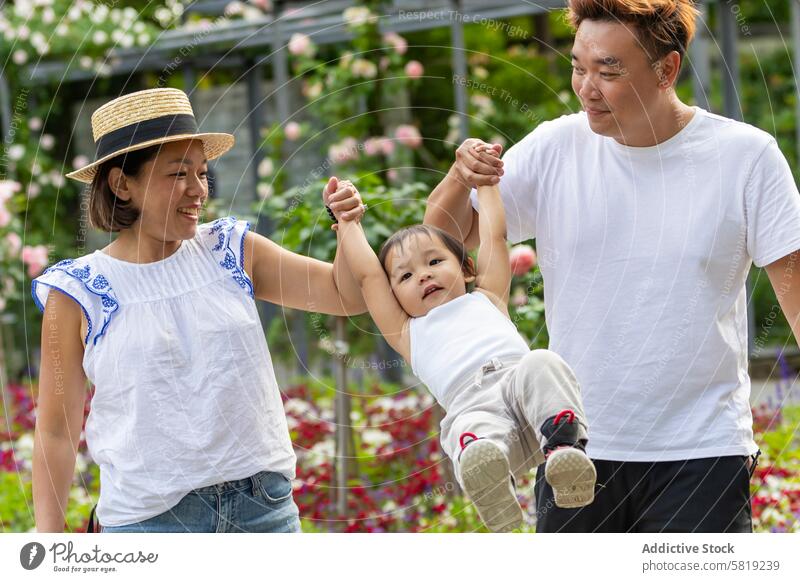 Asiatische Familie genießt einen spielerischen Moment im Europa-Urlaub asiatisch Garten Kind Eltern Zusammengehörigkeitsgefühl reisen Freizeit im Freien