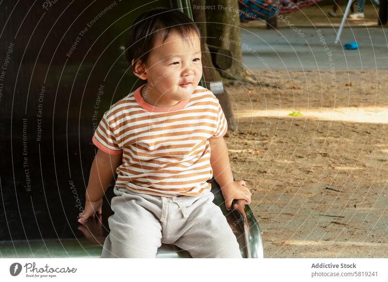 Kleinkind genießt einen sonnigen Park während eines Familienausflugs asiatisch Urlaub Europa Kind Lächeln reisen Sonnenlicht Sommer Freizeitkleidung