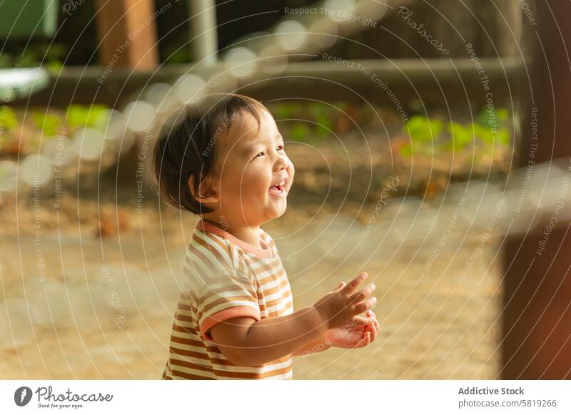 Asiatisches Kleinkind lacht im Freien auf Familienausflug in Europa asiatisch Kind Lachen Urlaub Park Freude Unschuld reisen Sommer Fröhlichkeit sonnig