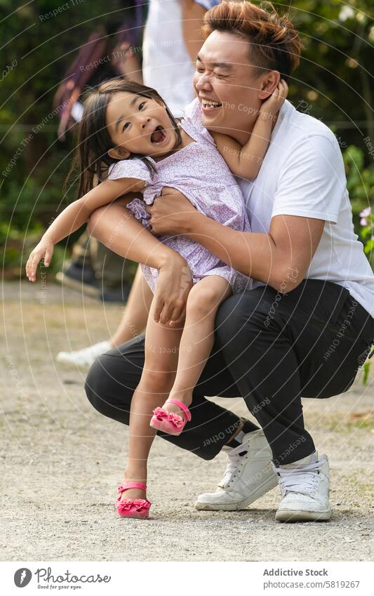 Fröhlicher asiatischer Vater, der mit seiner Tochter auf einer Europareise spielt Familie Urlaub spielen lachen reisen Freude Eltern Kind Fröhlichkeit Bonden