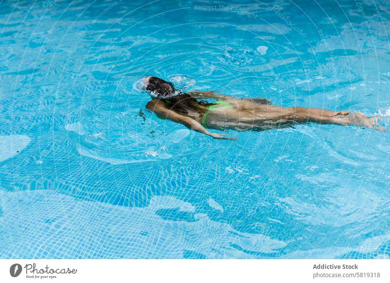 Junge Frau schwimmt Freistil in einem klaren blauen Pool Schwimmer Schwimmsport Wasser übersichtlich Freestyle Kraulen Fitness Sport Technik Sommer im Freien