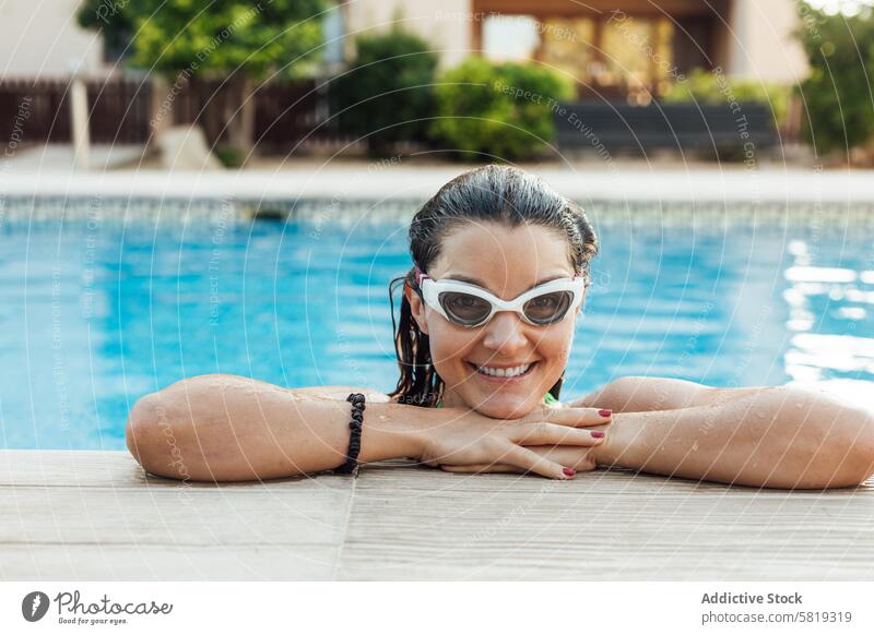 Frau genießt ein erfrischendes Bad in einem Pool schwimmen Schutzbrille Lächeln sonnig Tag Saum Genuss Wasser Freizeit im Freien Erholung Spaß Glück heiter nass