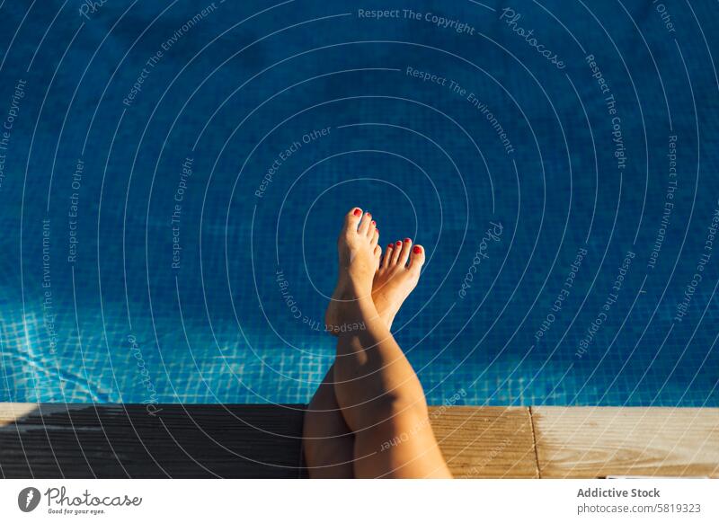 Entspannte Füße über einem Schwimmbad an einem sonnigen Tag Fuß Pool Wasser blau Erholung Sommer Urlaub Freizeit Frau Barfuß Pediküre rot nageln polnisch Ruhe