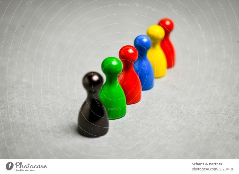 sechs Spielfiguren aus Holz in den Farben Schwarz, Grün, Rot, Blau und Gelb in einer Reihe schwarz grün rot blau gelb Politik Parteien Parteifarben Symbolik