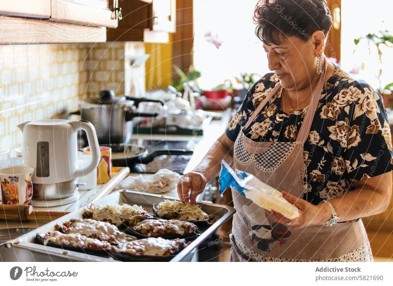 Ältere Frau bei der Zubereitung von Mahlzeiten in einer heimischen Küche Senior Essen zubereiten heimwärts Zubereitung von Speisen älter backen kulinarisch