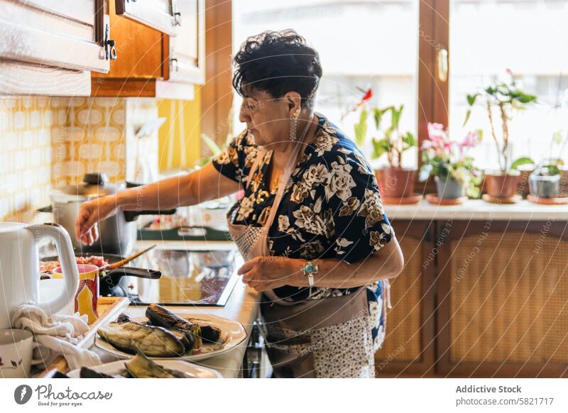 Ältere Dame bei der Zubereitung einer Mahlzeit in einer häuslichen Küche Senior Frau Essen zubereiten heimwärts Gemüse Utensilien älter Essenszubereitung