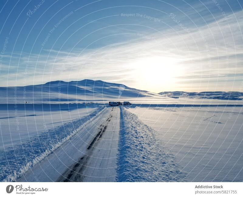 Winterstraße durch verschneite Landschaft in Island Schnee Straße Himmel blau Berge u. Gebirge Fahrzeug Gelassenheit übersichtlich entfernt geparkt riesig