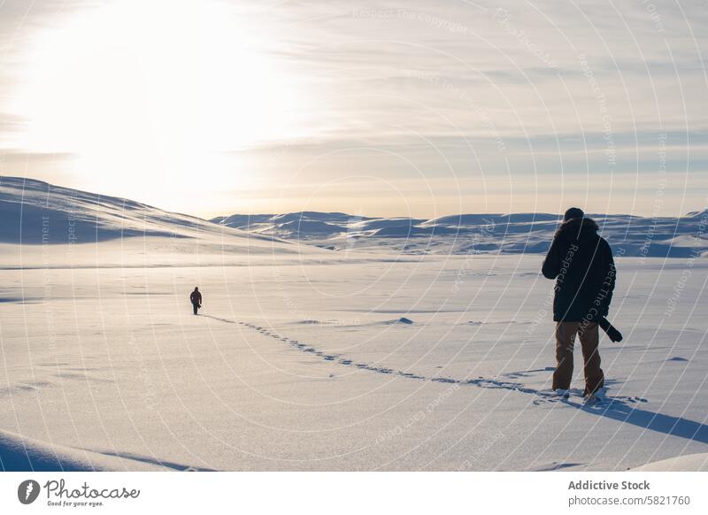 Ruhige Schneelandschaft in Island mit zwei Entdeckern Landschaft Winter Einsamkeit Himmel hell Gelassenheit riesig Fußstapfen Nachlauf kalt Natur im Freien