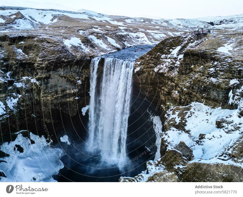 Majestätischer Wasserfall in einer verschneiten isländischen Landschaft Island Schnee Schlucht Natur im Freien Winter Kaskade malerisch besuchen reisen Klippe