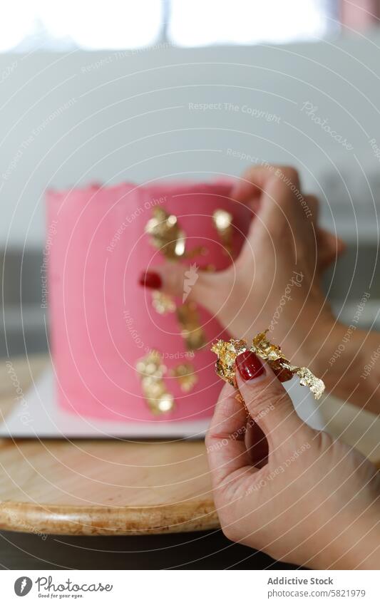 Dekorieren einer rosa Torte mit Blattgold-Akzenten Kuchen Dekoration & Verzierung GOLD LEAF backen Gebäck Kunst Zuckerguss Dessert Hand Nahaufnahme Konditorei