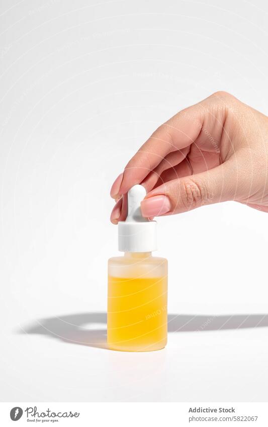 Frau hält ein Kosmetikserum mit gelber Flüssigkeit Hautpflege Schönheit Serum Flasche liquide Feuchtigkeitscreme Essenz Erdöl Behandlung Produkt