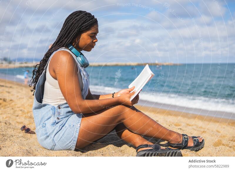 Junge Frau liest ein Buch am Strand von Barcelona lesen Sommer MEER jung Einsamkeit sandig Freizeit Erholung Küste Hafengebiet Urlaub reisen Feiertag ethnisch