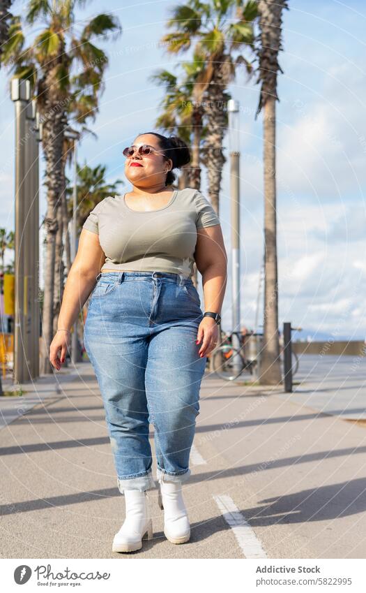 Ungezwungener Spaziergang an einem sonnigen Tag in Barcelona Frau Sommer Palme lässig Selbstvertrauen urban Lifestyle Freizeit schlendern Straße Mode Jeansstoff