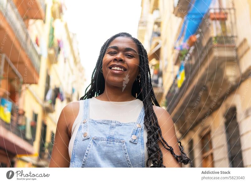 Junge Frau lächelt auf einer sonnigen Straße in Barcelona Lächeln Sommer reisen Freundschaft Gasse geflochtenes Haar jung heiter Urlaub Fröhlichkeit Europa