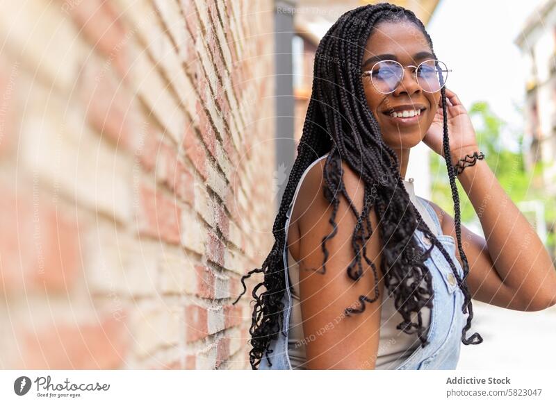 Stilvolle junge Frau genießt den Sommer in Barcelona Lächeln Sonnenbrille Zopf Glück Straße heiter sorgenfrei Jugend sonnig Großstadt Afroamerikaner Mode