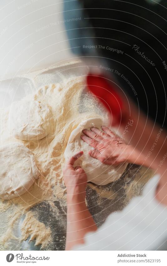Teigzubereitung in einer Pizzeria, Nahaufnahme und anonym Vorbereitung Teigwaren Hand Fähigkeit Arbeiter Pizza Mehl Oberfläche Gestaubt gesichtslos Kneten
