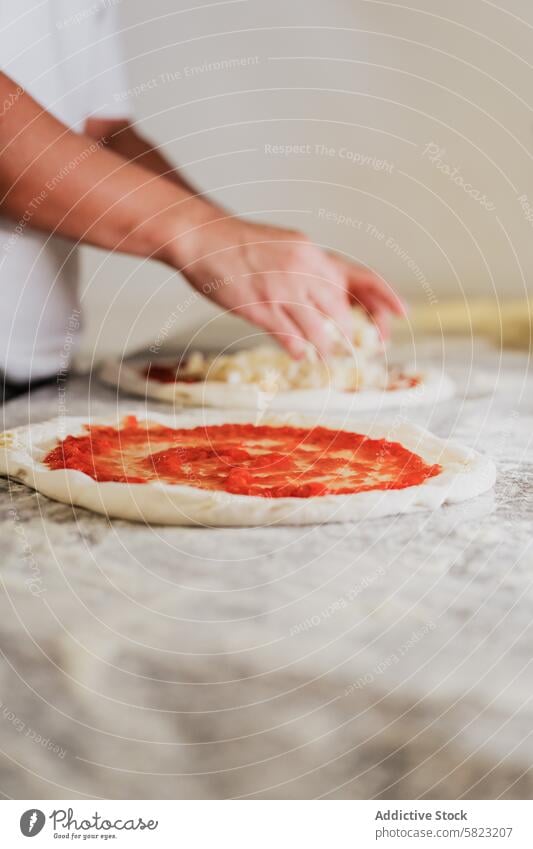 Handgemachte Pizza in einer Pizzeria-Küche zubereiten Vorbereitung Teigwaren Tomatensauce Käse Küchenchef handgefertigt Restaurant Essen zubereiten Lebensmittel