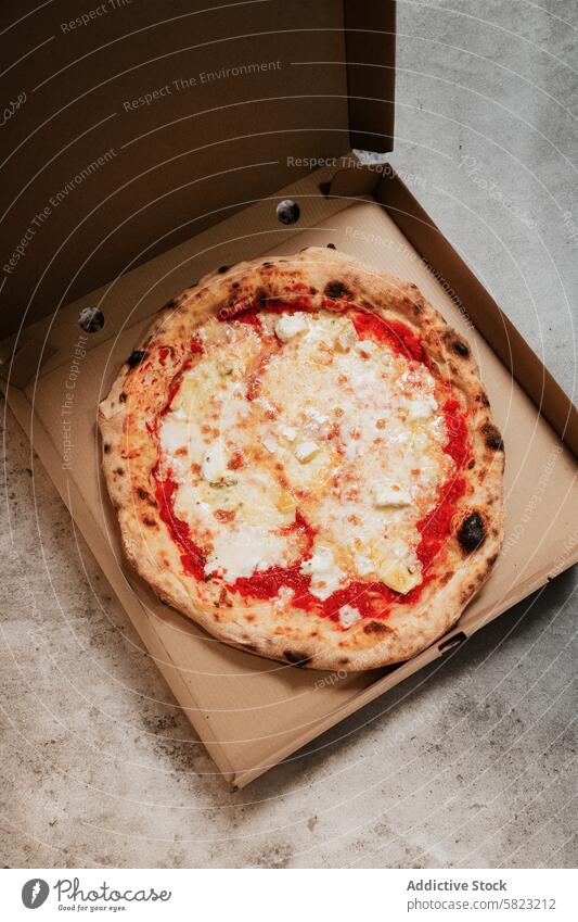 Frische Pizza in einer Schachtel auf einer Betonfläche Kasten Oberfläche Imbissbude Versand Pizzeria Lebensmittel Mahlzeit Käse Tomate Teigwaren gebacken Kruste