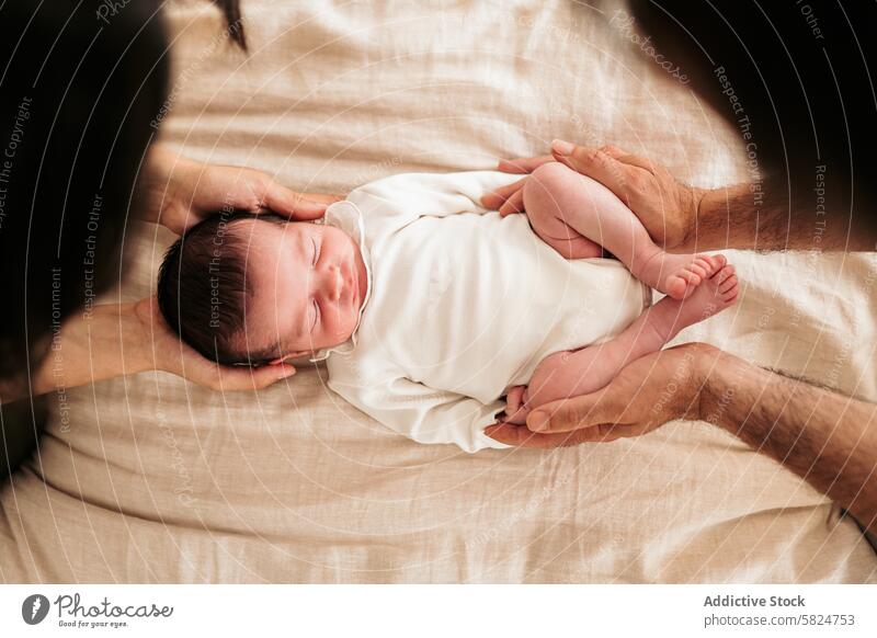 Neugeborenes Baby sanft in den Händen der Eltern gewiegt neugeboren Wiege schlafen friedlich sicheres Halt Liebe Pflege Kind Säugling ruhen beige Gewebe weich