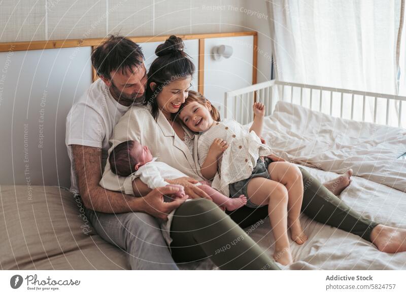 Familienbande mit Neugeborenem und Kleinkind im Bett Bonden neugeboren Schlafzimmer Lachen Eltern Freude Moment gemütlich Zusammensein Sitzen Mutter Vater