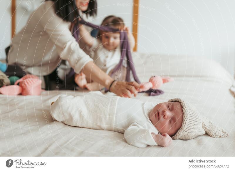 Zärtlicher Familienmoment mit Neugeborenem und Geschwisterkind neugeboren Baby Mutter Kleinkind Spielen schlafen Bett heimwärts im Innenbereich sanft Angebot
